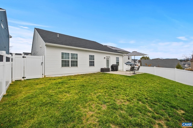 back of property with a patio, central air condition unit, and a lawn