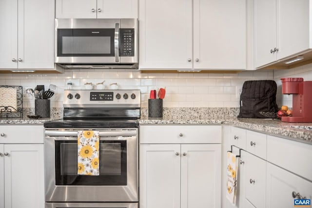 kitchen featuring decorative backsplash, light stone counters, white cabinets, and stainless steel appliances