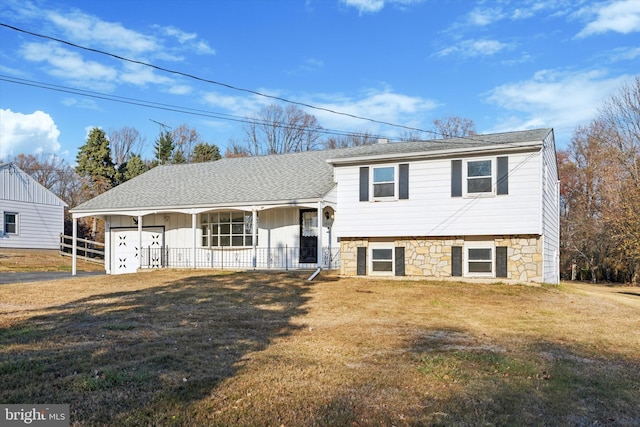 split level home featuring covered porch and a front lawn