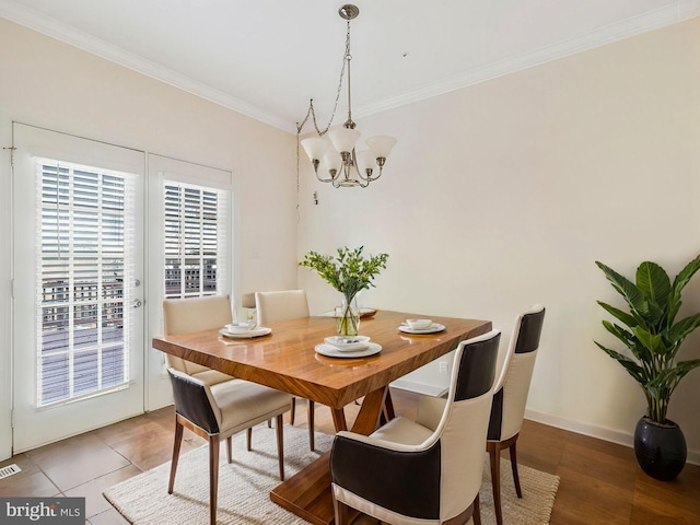 dining room with tile patterned flooring, an inviting chandelier, and ornamental molding