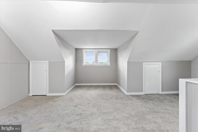 bonus room featuring light carpet and vaulted ceiling