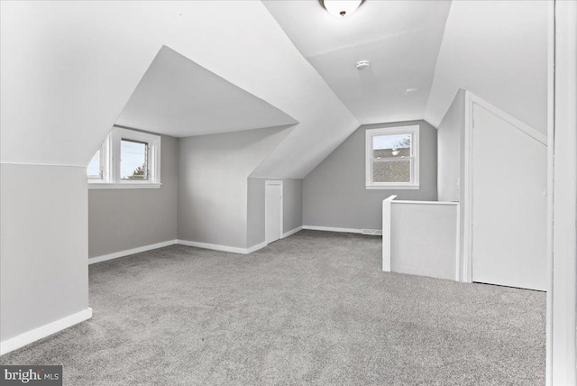 bonus room featuring light carpet and vaulted ceiling