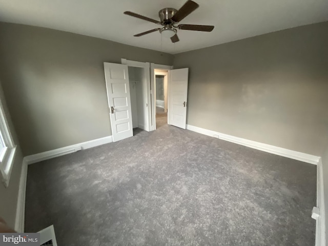 unfurnished bedroom featuring ceiling fan and dark colored carpet