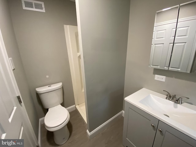 bathroom with vanity, toilet, and a shower