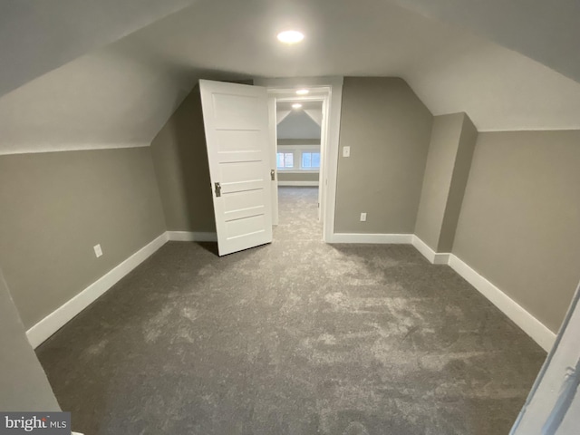 bonus room featuring dark colored carpet and lofted ceiling