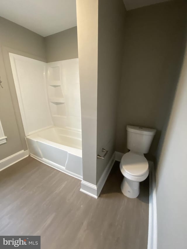 bathroom featuring shower / bathing tub combination, toilet, and wood-type flooring