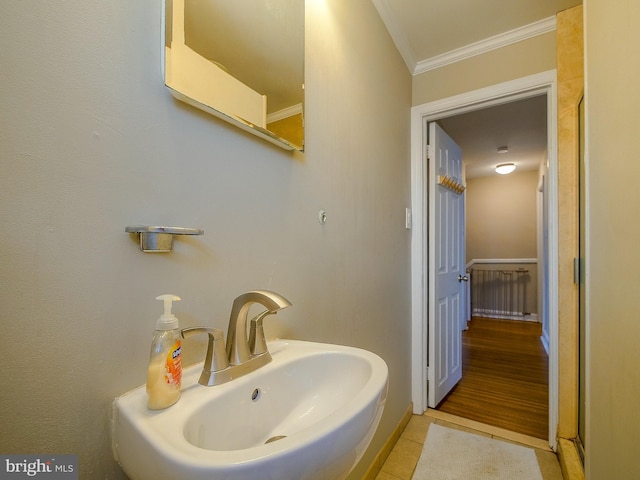 bathroom with crown molding, tile patterned floors, and a sink