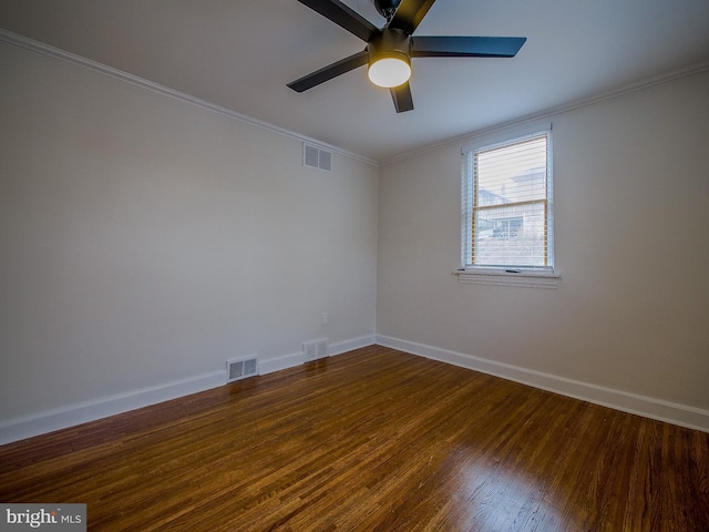 empty room with visible vents, baseboards, wood finished floors, and ornamental molding