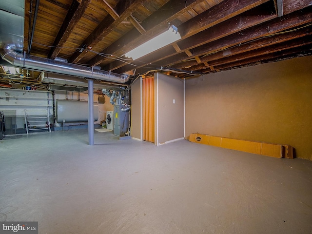 unfinished basement with washer / dryer and heating fuel