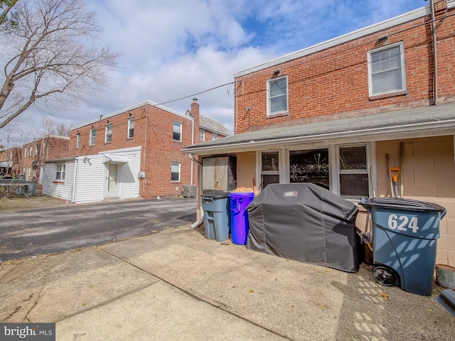 rear view of house with central air condition unit and brick siding