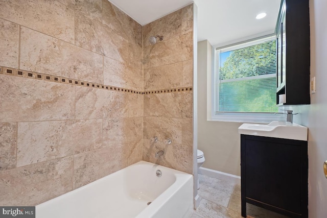 full bathroom featuring toilet, tiled shower / bath, and vanity