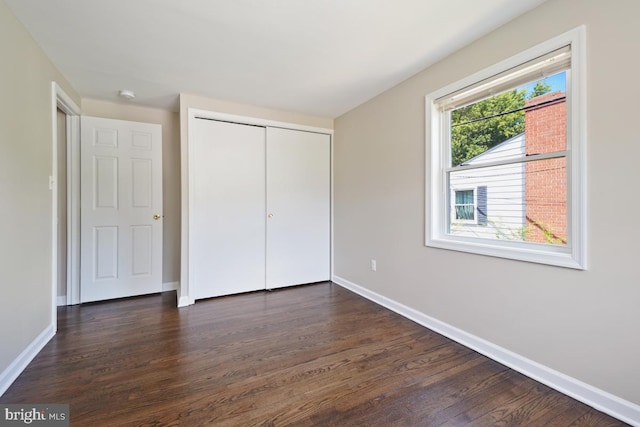 unfurnished bedroom featuring dark wood-type flooring and a closet