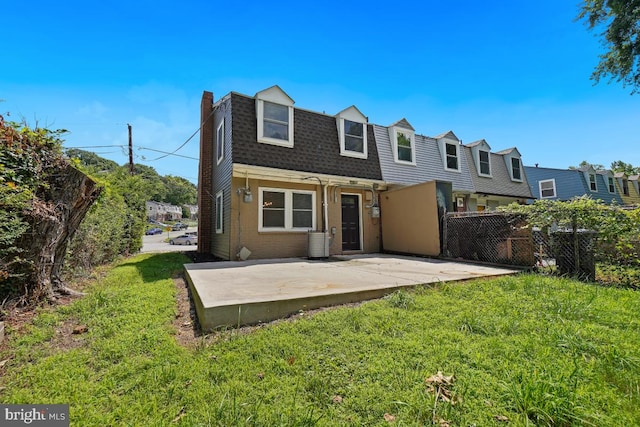 back of property with a patio area and a yard