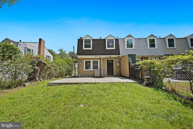 back of property with a yard and a patio