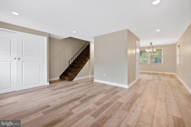 spare room featuring light hardwood / wood-style flooring and a chandelier