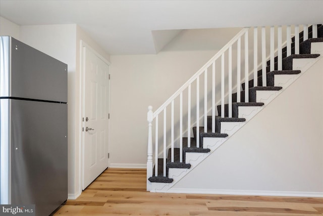 stairs featuring hardwood / wood-style floors