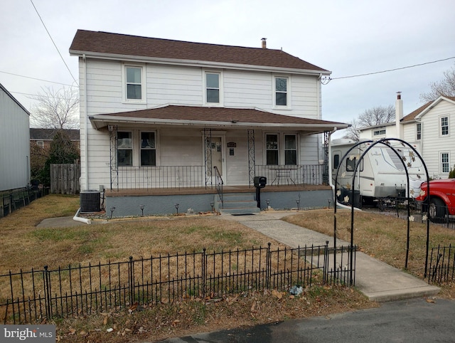 view of front of house featuring cooling unit, covered porch, and a front yard