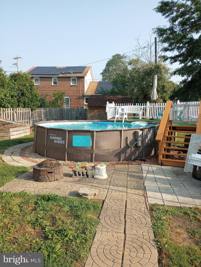 view of pool with an outdoor fire pit and a patio