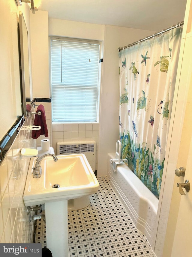 bathroom featuring radiator heating unit, tile walls, and shower / bath combo