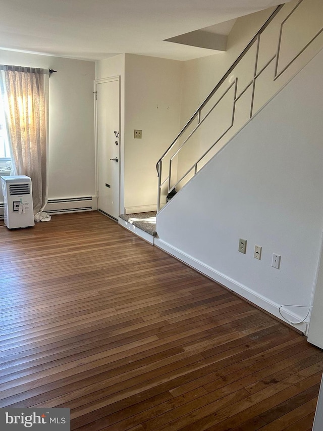 foyer featuring a wall unit AC, dark hardwood / wood-style flooring, and a baseboard radiator