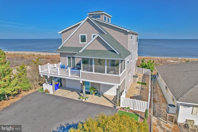 exterior space with a water view, a garage, and a balcony