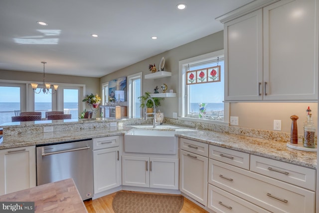 kitchen featuring light wood-type flooring, white cabinets, a water view, dishwasher, and a chandelier