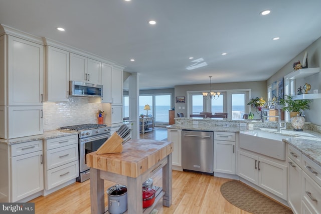 kitchen featuring white cabinets, a water view, and appliances with stainless steel finishes