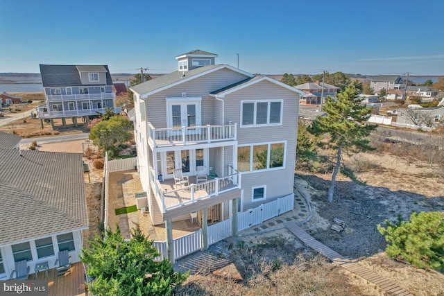 back of property featuring a balcony and french doors