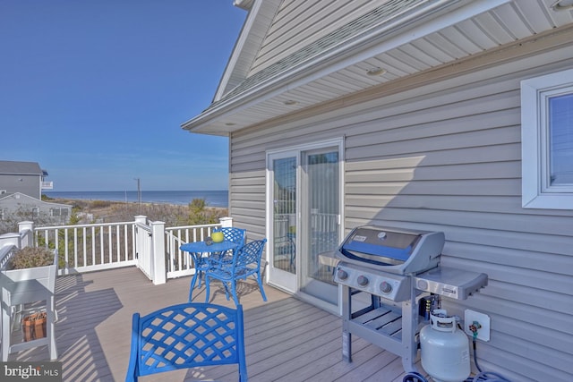 wooden terrace featuring grilling area and a water view