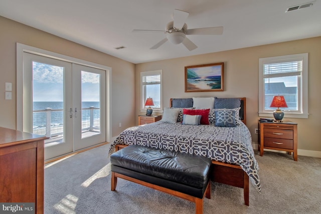 bedroom with access to outside, multiple windows, french doors, and a water view