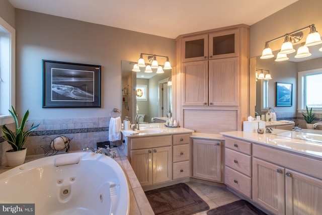 bathroom featuring tile patterned floors, tiled bath, and vanity