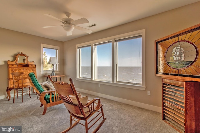 living area featuring ceiling fan and carpet