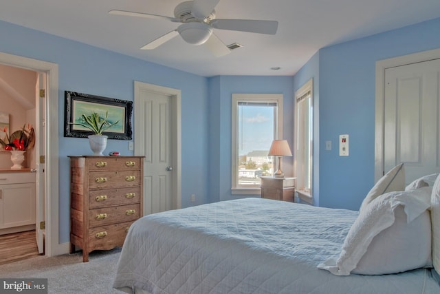 carpeted bedroom with connected bathroom and ceiling fan