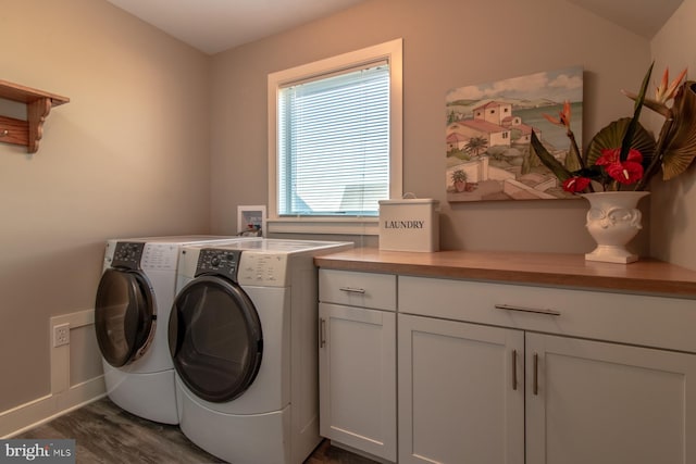 laundry area featuring cabinets, dark wood-type flooring, and washing machine and clothes dryer