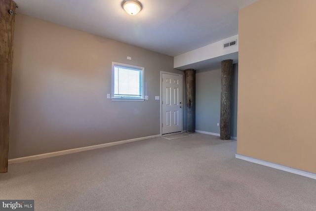 unfurnished room featuring light carpet