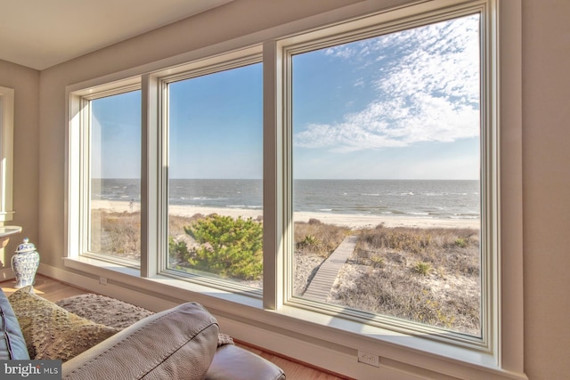 interior space featuring a water view, a beach view, and hardwood / wood-style flooring