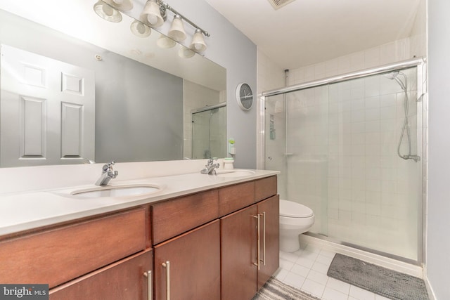 bathroom with tile patterned flooring, vanity, toilet, and a shower with shower door