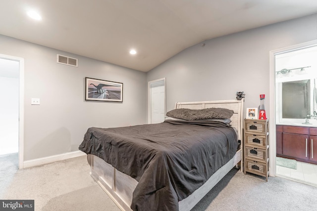 bedroom with connected bathroom, light colored carpet, lofted ceiling, and sink