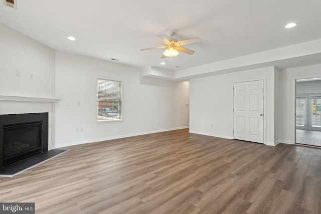 unfurnished living room featuring plenty of natural light, ceiling fan, and wood-type flooring