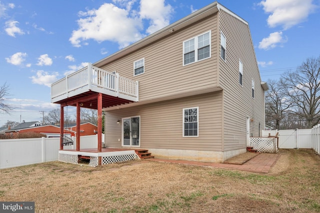 rear view of house with a lawn and a wooden deck