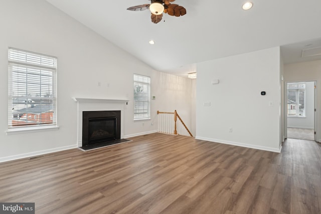 unfurnished living room with wood-type flooring, high vaulted ceiling, a wealth of natural light, and ceiling fan