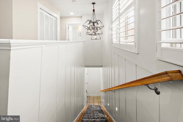 stairs featuring tile patterned floors and a chandelier