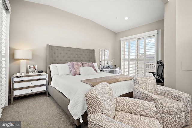 bedroom with light colored carpet and lofted ceiling