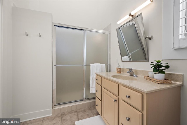 bathroom featuring tile patterned floors, vanity, and a shower with shower door