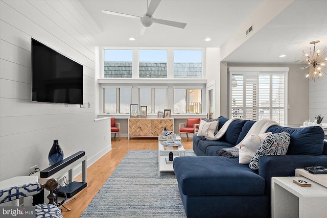 living room with a notable chandelier, a healthy amount of sunlight, and light hardwood / wood-style flooring