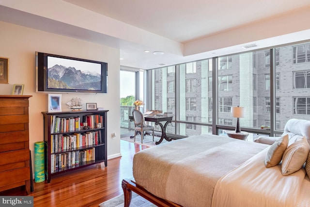 bedroom featuring wood-type flooring and expansive windows