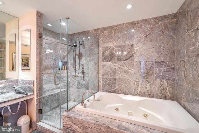 bathroom with shower with separate bathtub and tile walls