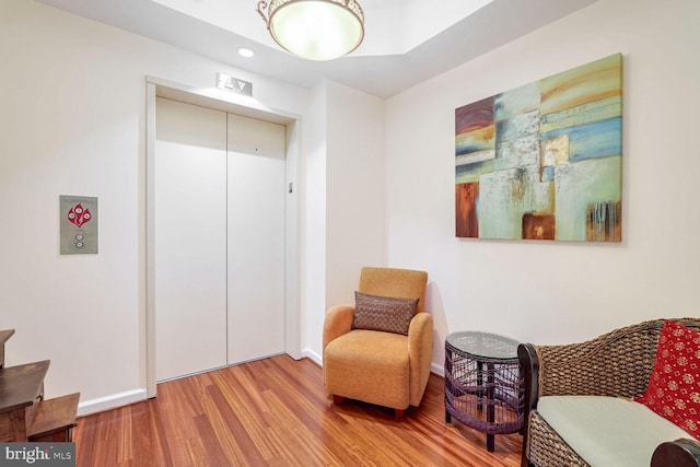 living area with hardwood / wood-style flooring and elevator