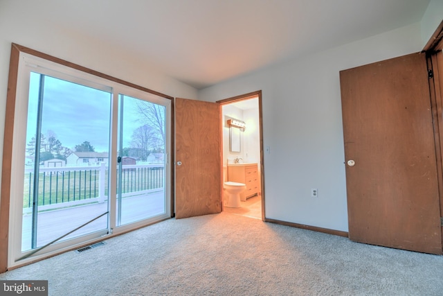 unfurnished bedroom featuring carpet flooring, sink, access to outside, and ensuite bath