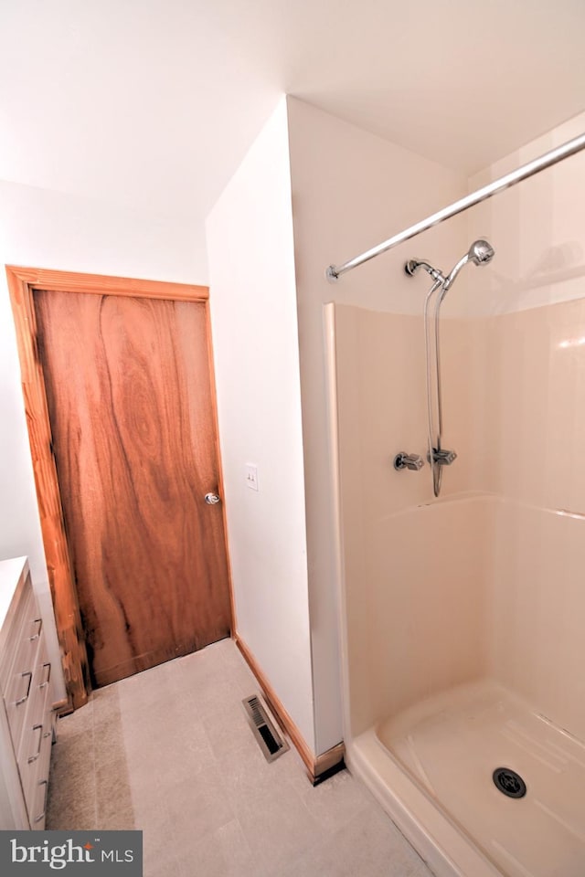 bathroom featuring a shower and vanity